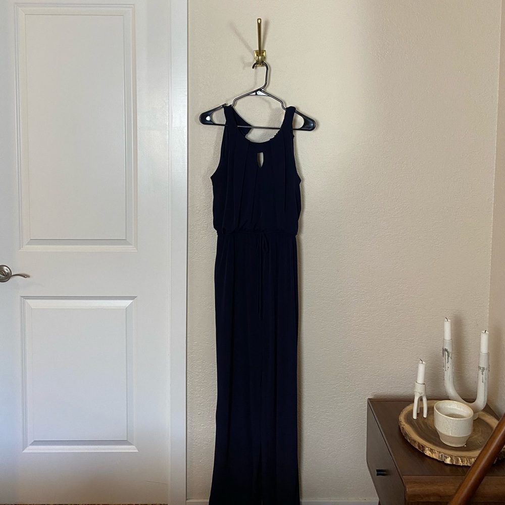 Navy sleeveless women’s jumpsuit with next detail and waist detail.